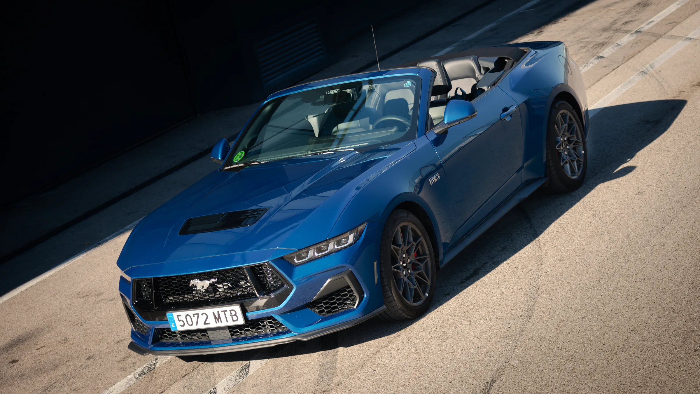 Ford Mustang descapotable azul en una pista